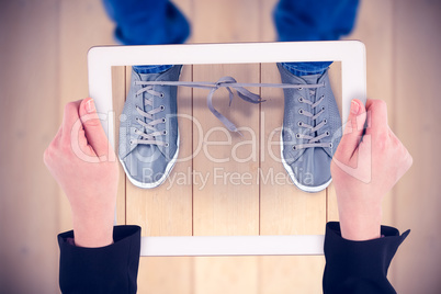 Composite image of feminine hands holding tablet