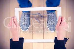 Composite image of feminine hands holding tablet