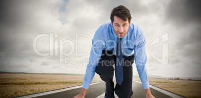 Composite image of focused businessman ready to race