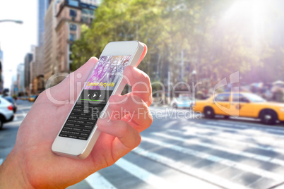 Composite image of hand holding smartphone