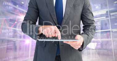 Composite image of businessman using his tablet pc