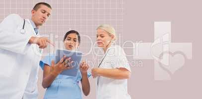 Composite image of doctors looking together at tablet