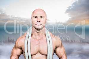 Composite image of portrait of confident fit man with rope aroun