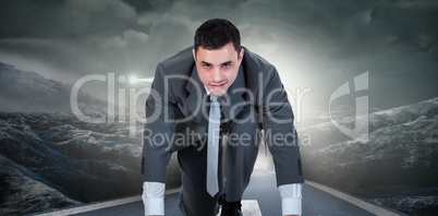 Composite image of businessman ready to race