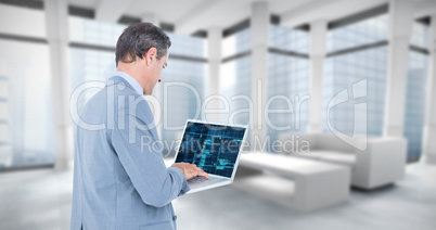 Composite image of businessman using laptop