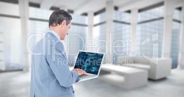 Composite image of businessman using laptop