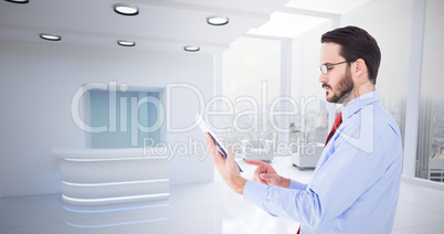 Composite image of businessman scrolling on his digital tablet