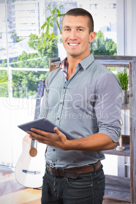 Composite image of handsome businessman using digital tablet ove