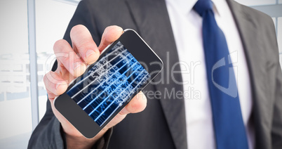 Composite image of businessman showing his smartphone screen