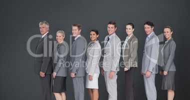 Composite image of business team standing in row and smiling at