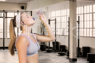 Composite image of sporty blonde drinking water