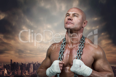 Composite image of confident bodybuilder holding chain while loo