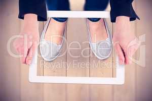 Composite image of feminine hands holding tablet