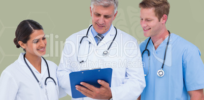 Composite image of doctor working with colleagues while holding
