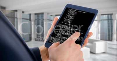 Composite image of businessman using digital tablet over white b