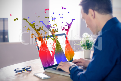 Composite image of businessman using laptop at table in office