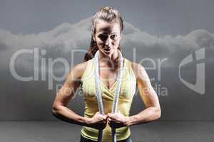 Composite image of portrait of healthy woman holding rope around