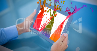 Composite image of businessman using his tablet