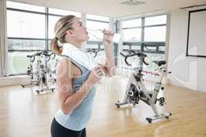 Composite image of fit woman drinking water