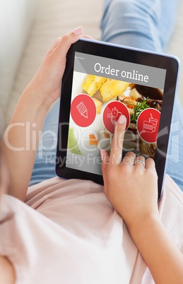 Composite image of girl using her tablet on the couch