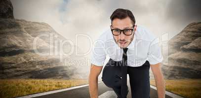Composite image of geeky young businessman ready to race