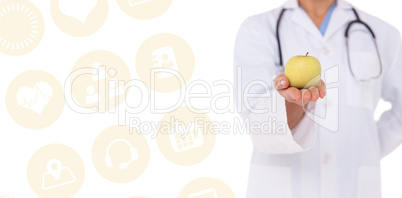 Composite image of smiling doctor offering an apple