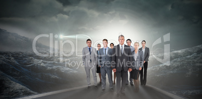 Composite image of smiling business team looking at camera
