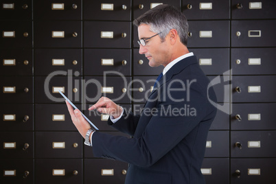 Composite image of mid section of a businessman touching tablet