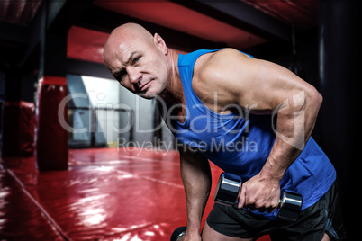Composite image of portrait of fit man exercising with dumbbells