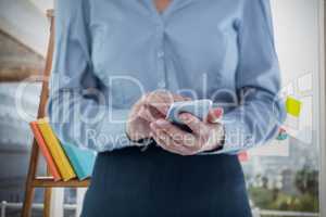 Composite image of businesswoman using smart phone