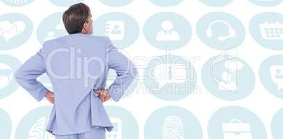 Composite image of  serious businessman with hands on hips