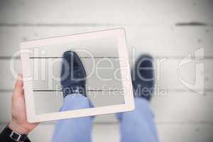 Composite image of masculine hand holding tablet