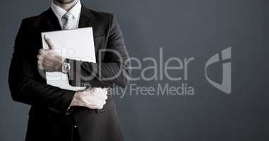 Composite image of mid section of businessman holding computer