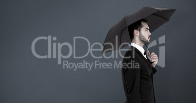 Composite image of businessman under umbrella while holding a br