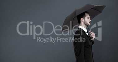 Composite image of businessman under umbrella while holding a br