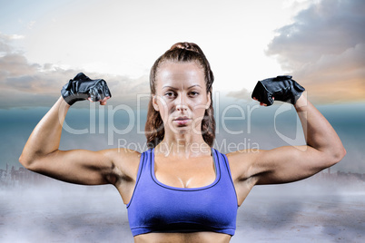 Composite image of portrait of woman with gloves flexing muscles