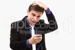 Young businessman amazedly looking at the phone holding on to th