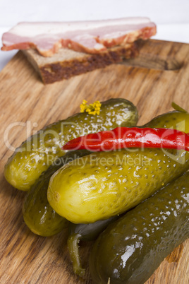 Pickled cucumbers with red hot pepper on a cutting board