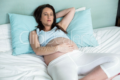 Pregnant woman resting on her bed