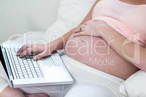 Pregnant woman relaxing with her laptop