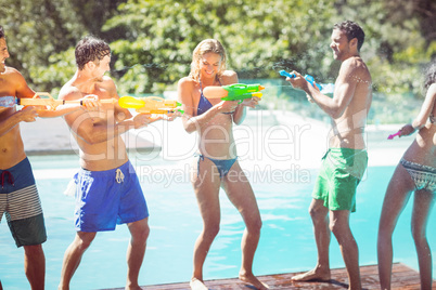Happy friends doing water gun battle