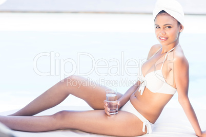 Smiling brunette holding glass of water