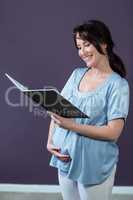 Pregnant woman reading notebook