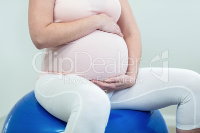 Pregnant woman sitting on exercise ball