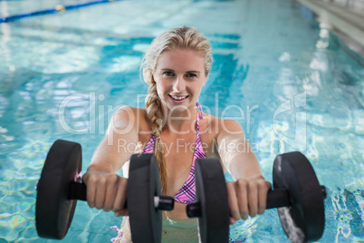 Attractive woman lifting dumbbells