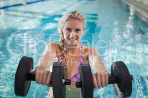 Attractive woman lifting dumbbells