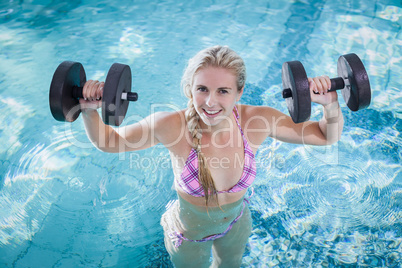 Attractive woman lifting dumbbells
