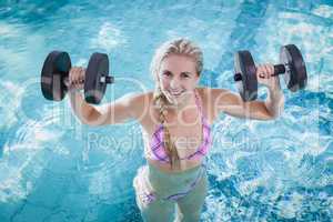 Attractive woman lifting dumbbells