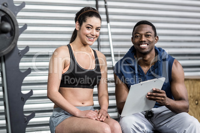 Athletic woman and trainer smiling to camera
