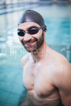 Smiling man wearing swim cap and goggles